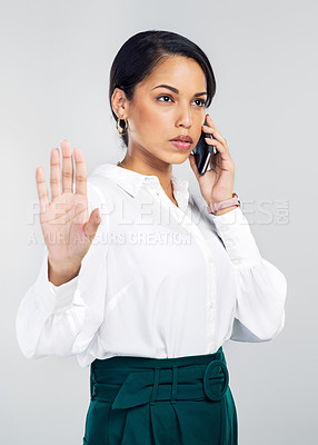 Buy stock photo Studio shot of a young businesswoman using a smartphone and gesturing to hold against a grey background