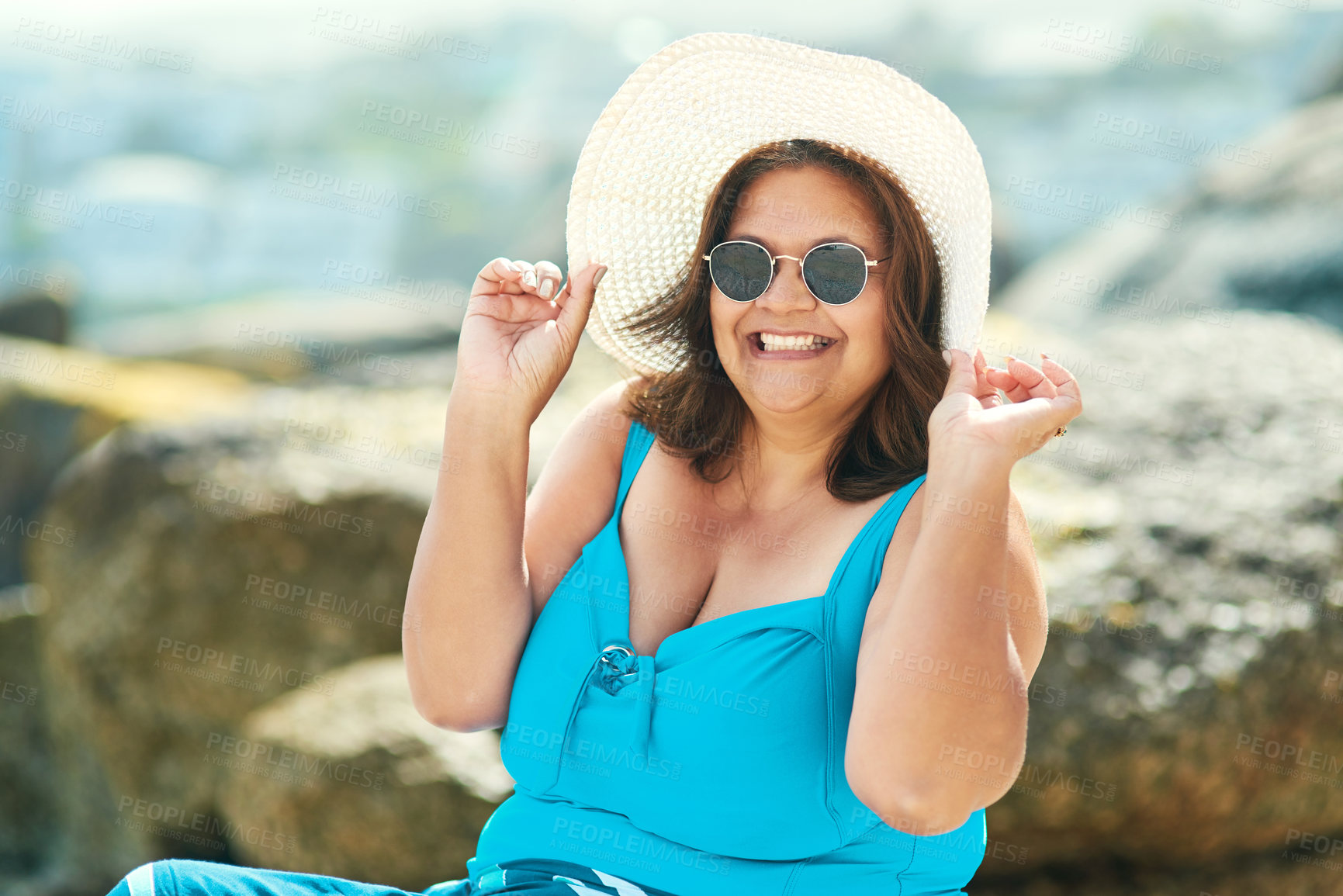 Buy stock photo Shot of an attractive mature woman sitting alone during a day out on the beach