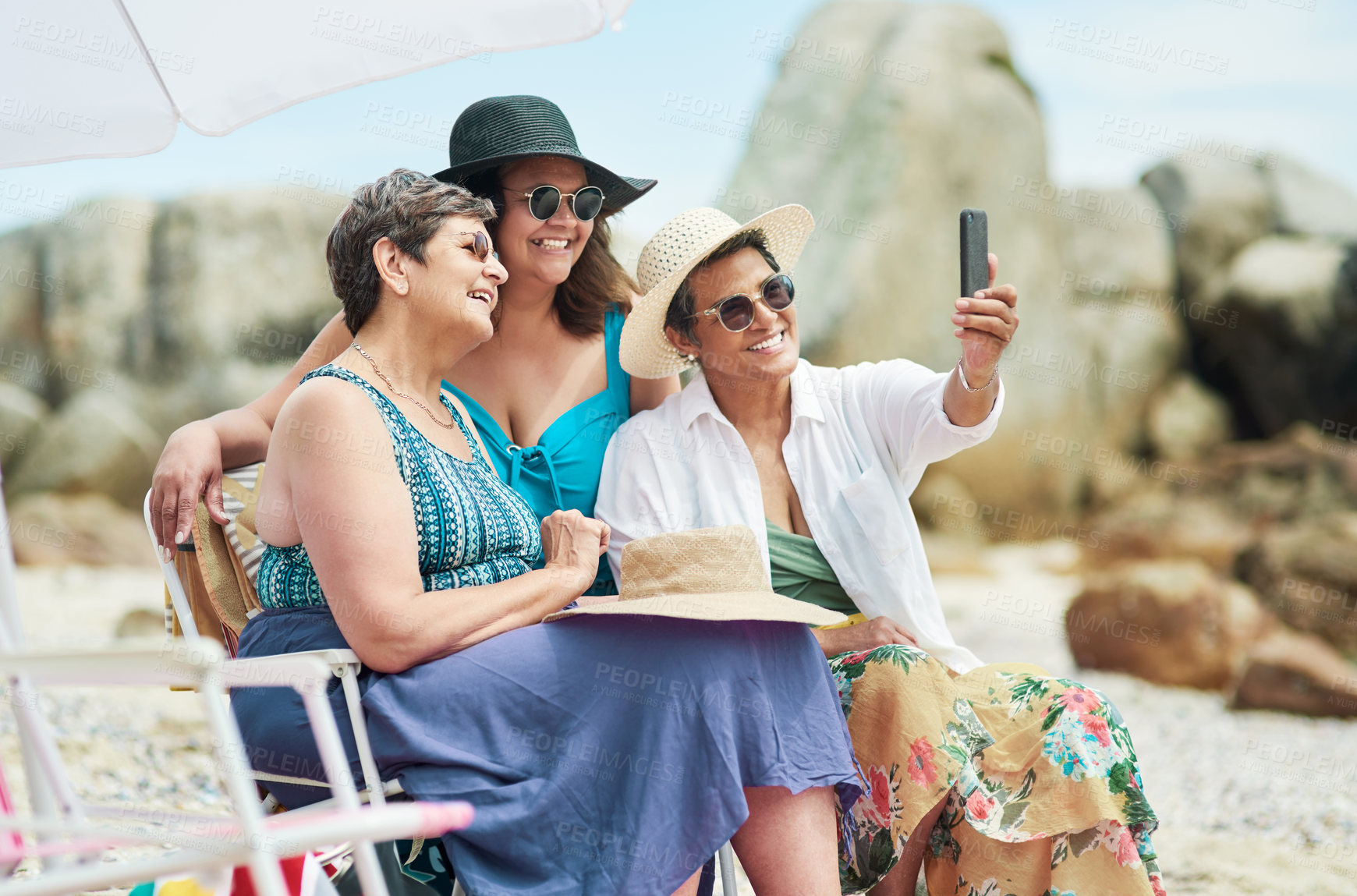 Buy stock photo Shot of a mature group of friends posing together for a selfie on the beach