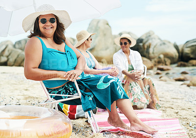 Buy stock photo Shot of a mature woman sitting and enjoy a day out on the beach with friends