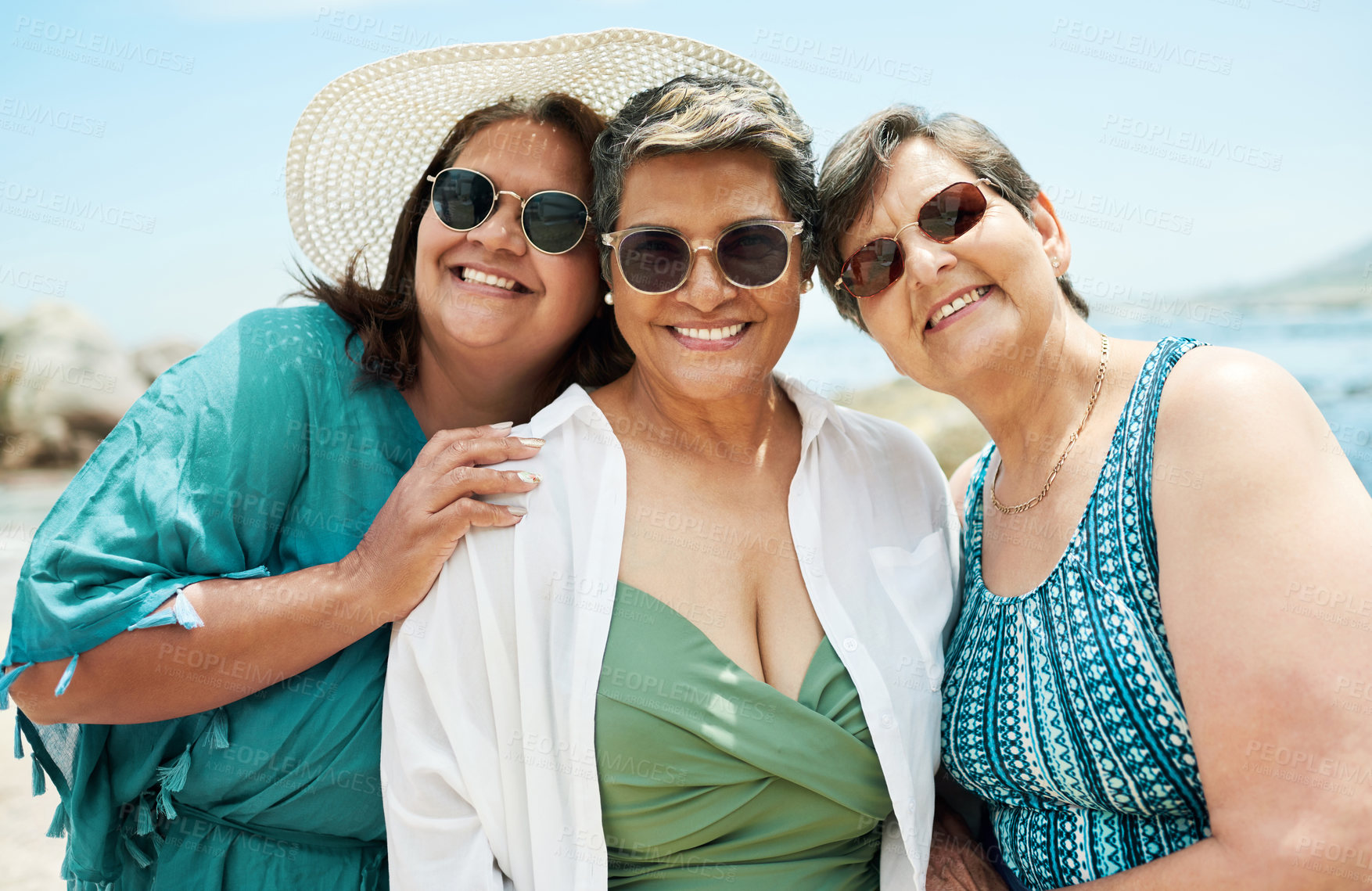 Buy stock photo Shot of a mature group of friends standing together during a day out on the beach