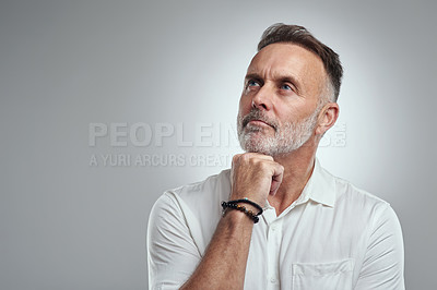Buy stock photo Studio shot of a mature man looking thoughtful against a grey background