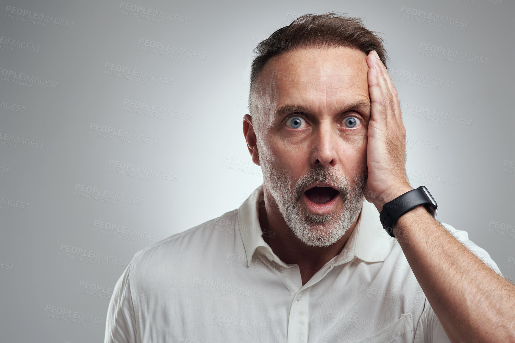 Buy stock photo Studio portrait of a mature man looking surprised against a grey background