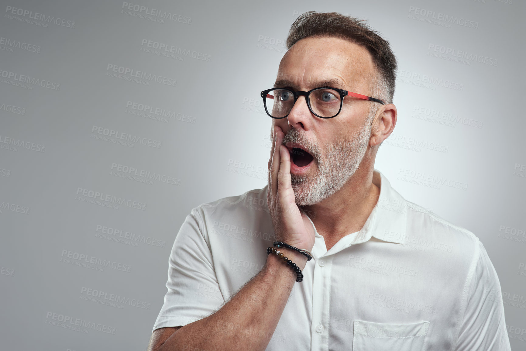 Buy stock photo Studio shot of a mature man looking surprised against a grey background