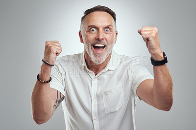 Buy stock photo Studio portrait of a mature man cheering against a grey background