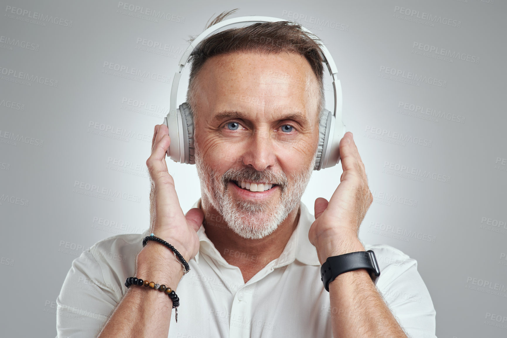 Buy stock photo Studio portrait of a mature man wearing headphones against a grey background