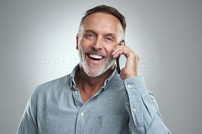 Buy stock photo Studio portrait of a mature man talking on a cellphone against a grey background