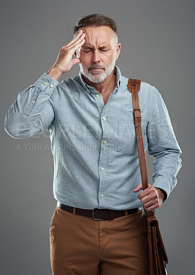 Buy stock photo Studio shot of a mature man experiencing a headache and looking stressed out against a grey background