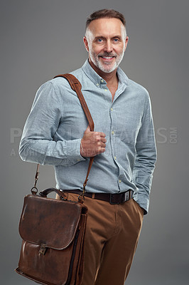Buy stock photo Studio portrait of a mature man carrying a bag against a grey background