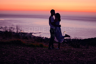 Buy stock photo Full length shot of an affectionate young couple silhouetted at sunset