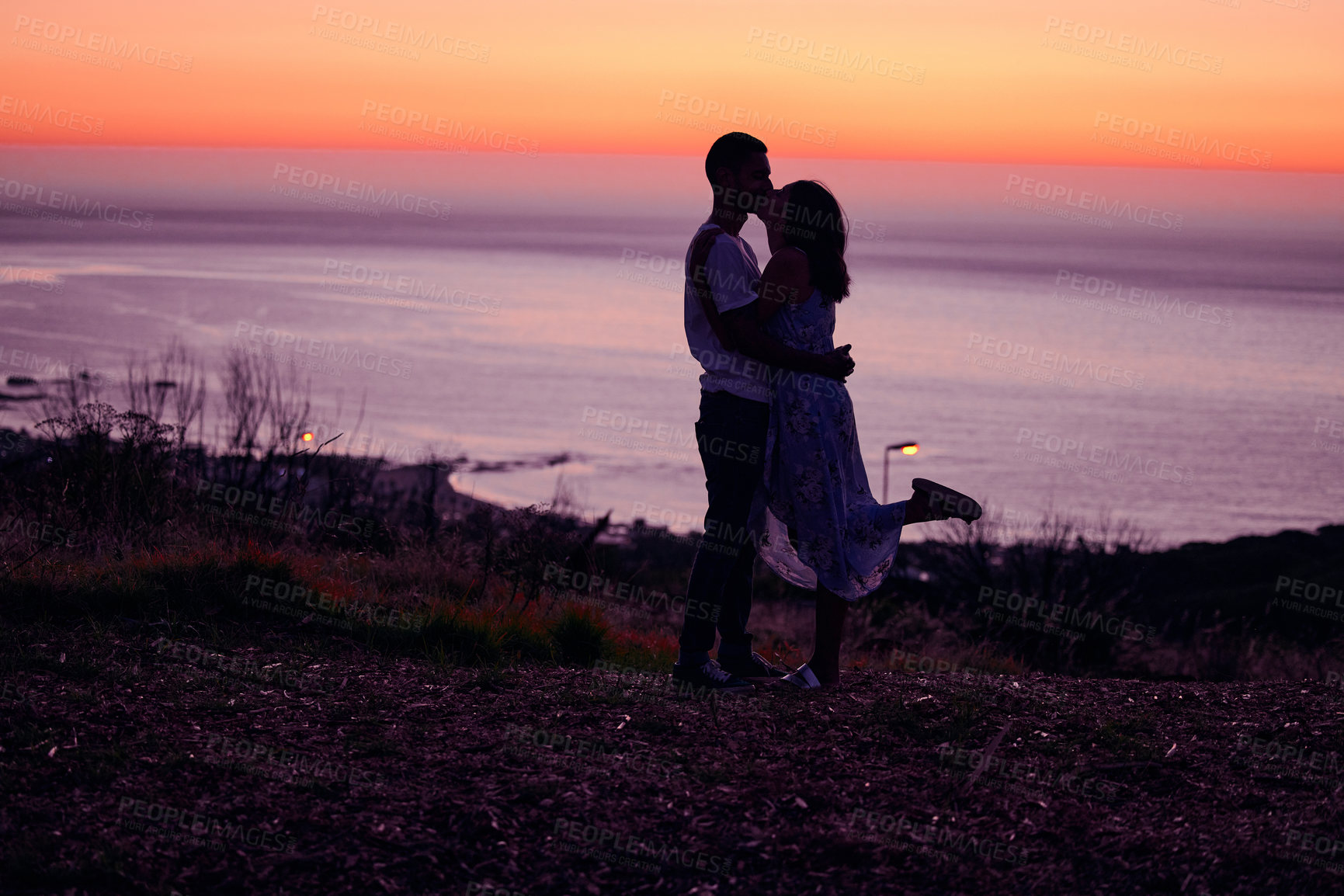 Buy stock photo Full length shot of an affectionate young couple silhouetted at sunset