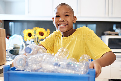 Buy stock photo Shot of a young boy getting ready to recycle some bottles at home