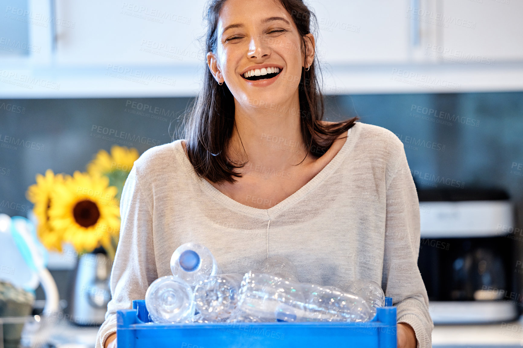 Buy stock photo Shot of a young woman getting ready to recycle some bottles at home