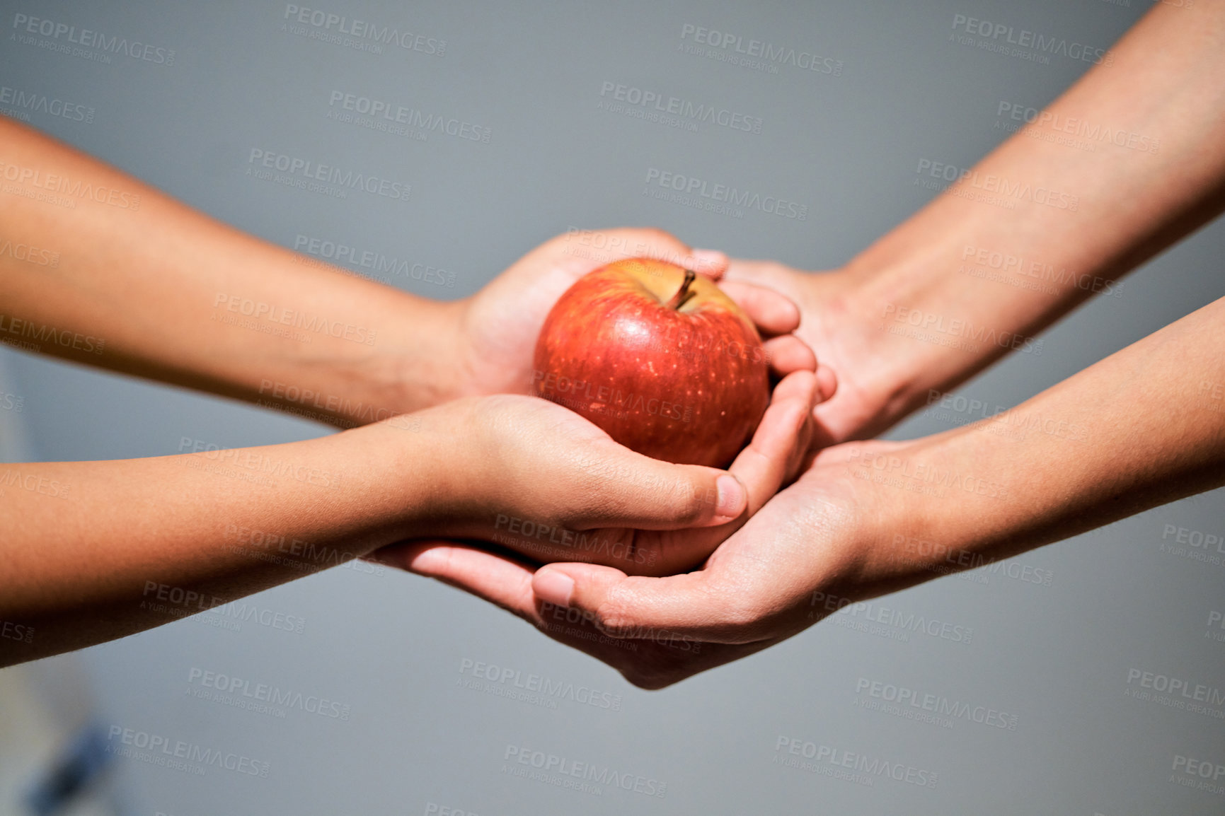 Buy stock photo Studio shot of an unrecognizable woman giving a child an apple