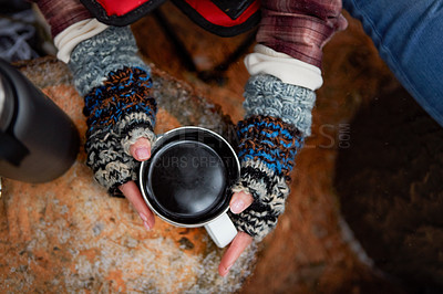Buy stock photo High angle shot of an unrecognisable woman drinking a warm beverage while camping in the wilderness during winter