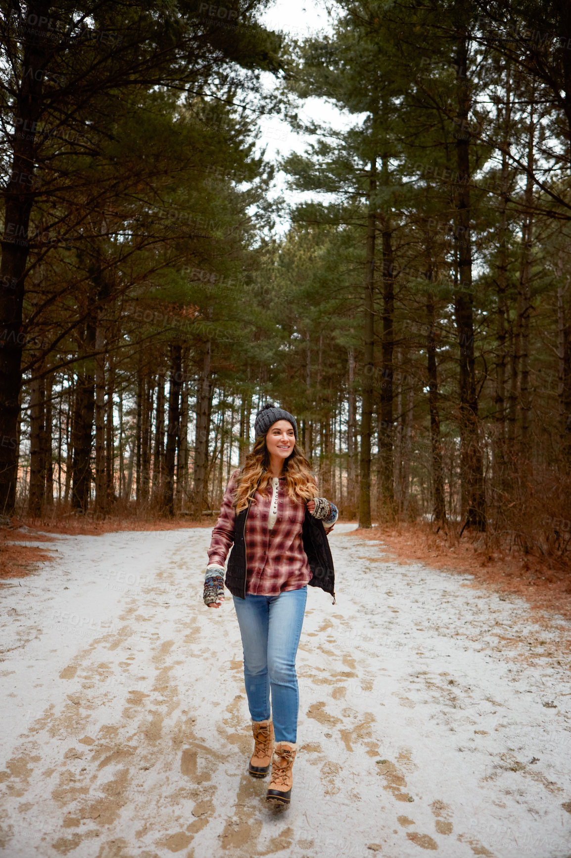 Buy stock photo Shot of a young woman hiking in the wilderness during winter