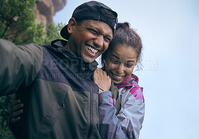 Buy stock photo Cropped shot of an affectionate young couple laughing while taking a selfie during their early morning hike