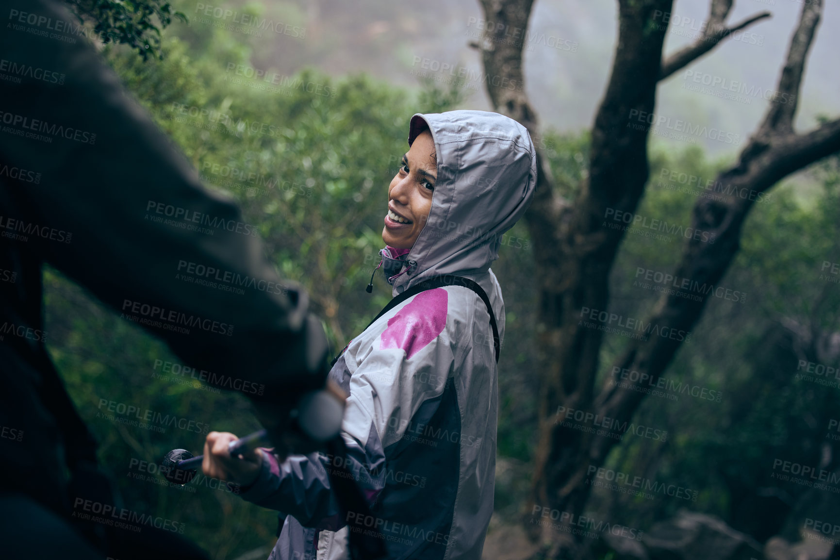 Buy stock photo Happy woman, hiking and helping with partner in rainforest or support on adventure or outdoor journey. Female person with smile, raincoat or stick for hike or trekking in winter, woods or nature