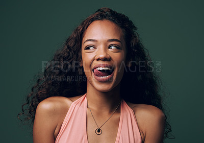 Buy stock photo Cropped shot of an attractive and quirky young woman posing against a green background in studio