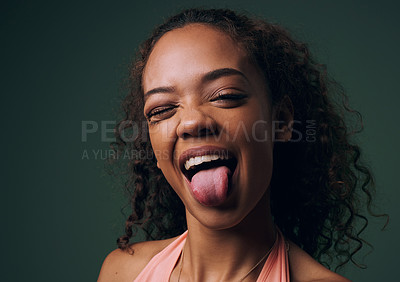 Buy stock photo Cropped portrait of an attractive and quirky young woman posing against a green background in studio