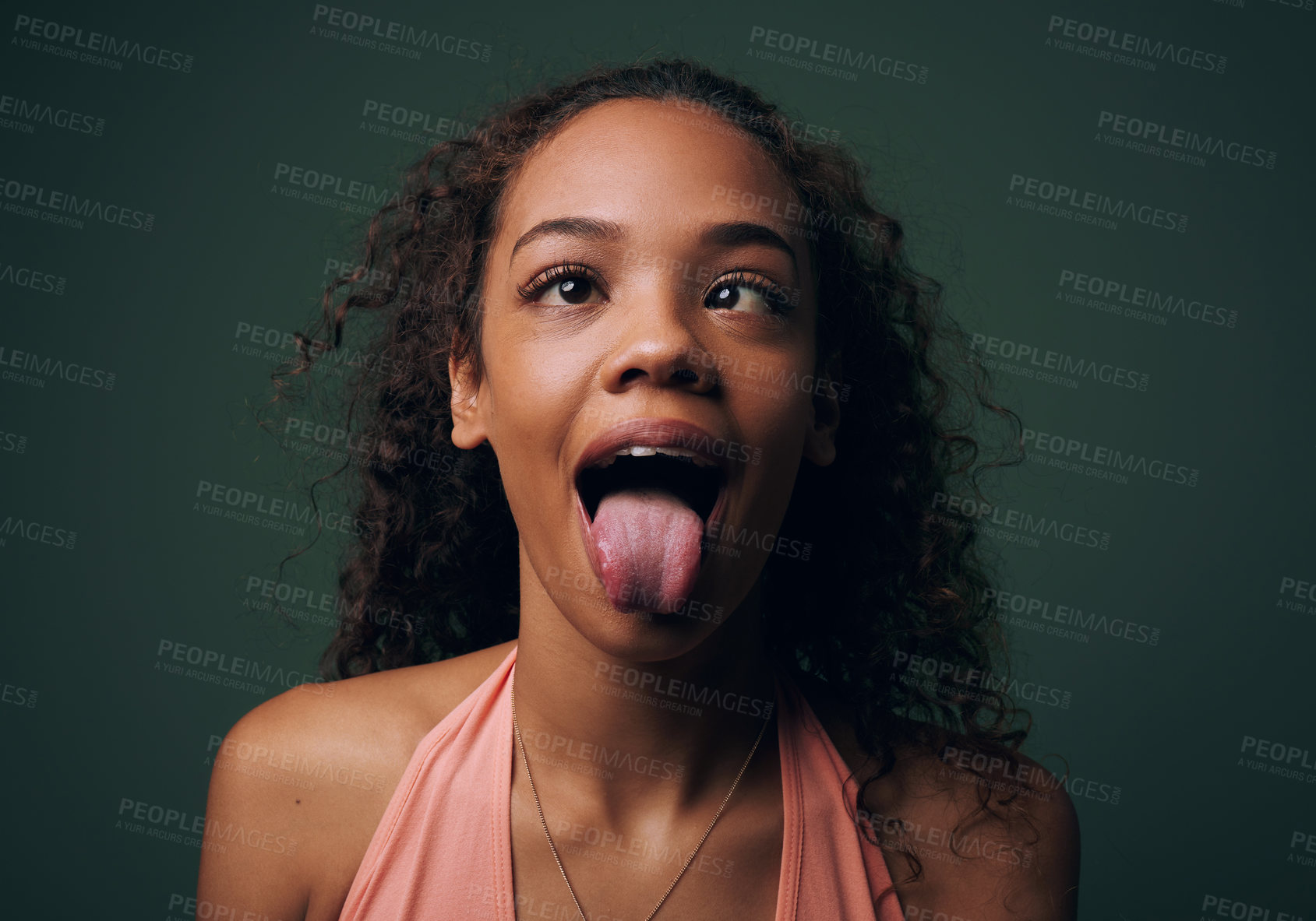 Buy stock photo Cropped shot of an attractive and quirky young woman posing against a green background in studio