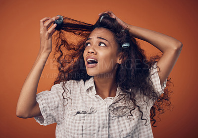 Buy stock photo Woman, hair roller and stuck or disappointed with damage in studio on brown background with shock, treatment and bad results. Female person, isolated and upset at style with stress and frustrated