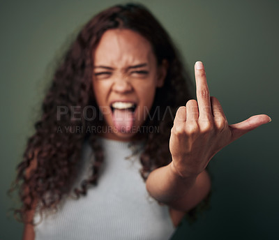 Buy stock photo Studio shot of a young woman showing her middle finger against a green background