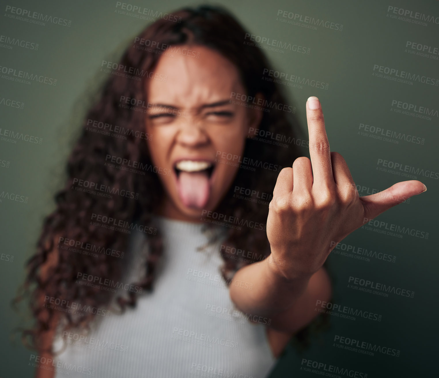 Buy stock photo Portrait, girl and middle finger sign with studio for expression or conflict, rebel and fuck you for opinion. Woman, isolated and green background with hand gesture for hate with tongue out and rude.