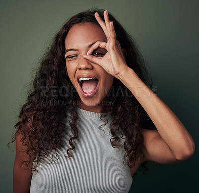 Buy stock photo Circle, hand and portrait of black girl in studio for peek a boo or i see you, perfect sign and wow. Woman, isolated and green background with ok gesture for feedback and expression with approval.