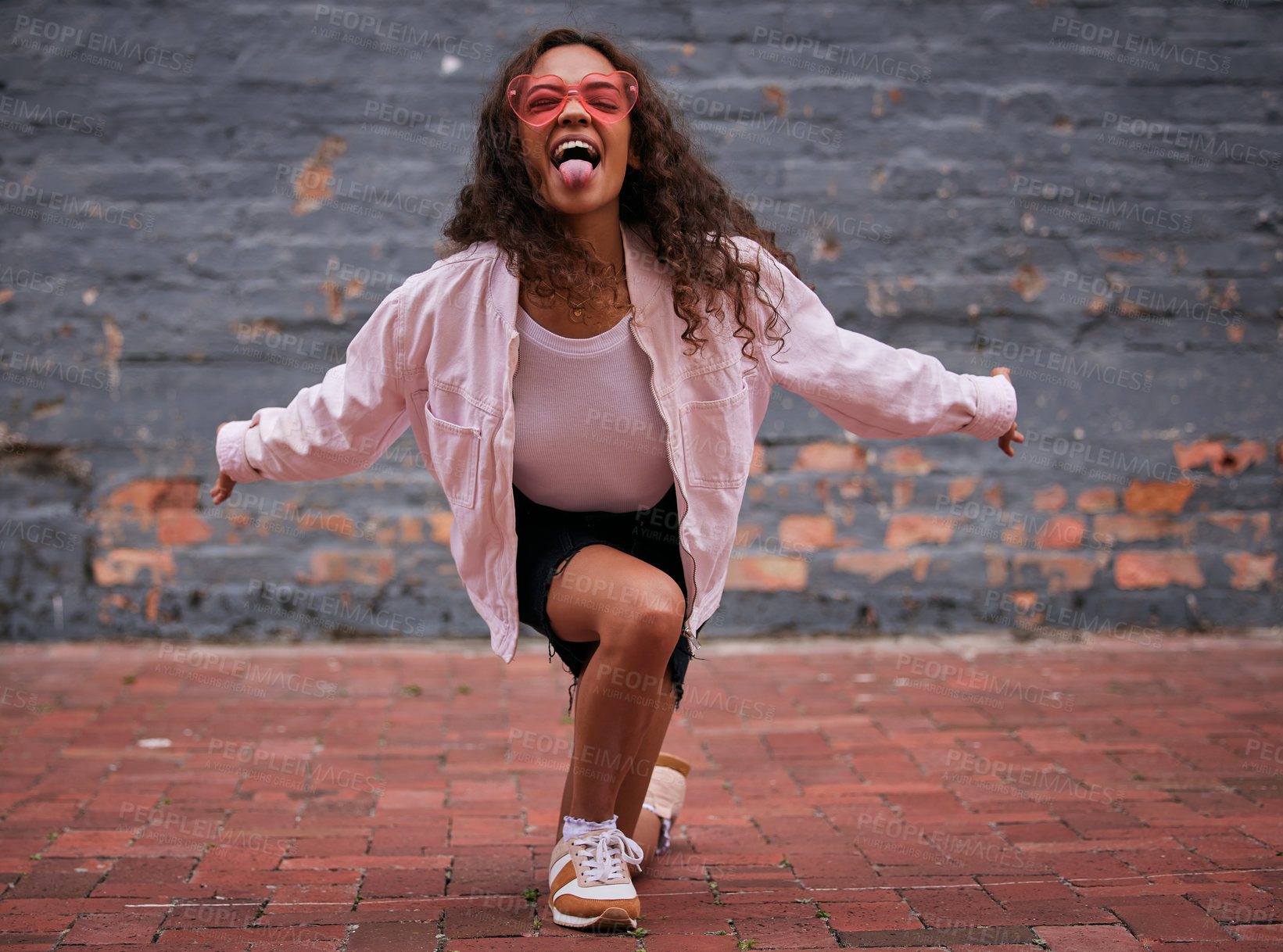 Buy stock photo African girl, outdoor and dancing with cool fashion, style and portrait in heart shaped sunglasses. Young person or gen z with tongue for confidence, energy and hip hop in pink aesthetic and clothes