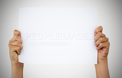 Buy stock photo Studio shot of an unrecognisable woman holding up a blank sign against a grey background