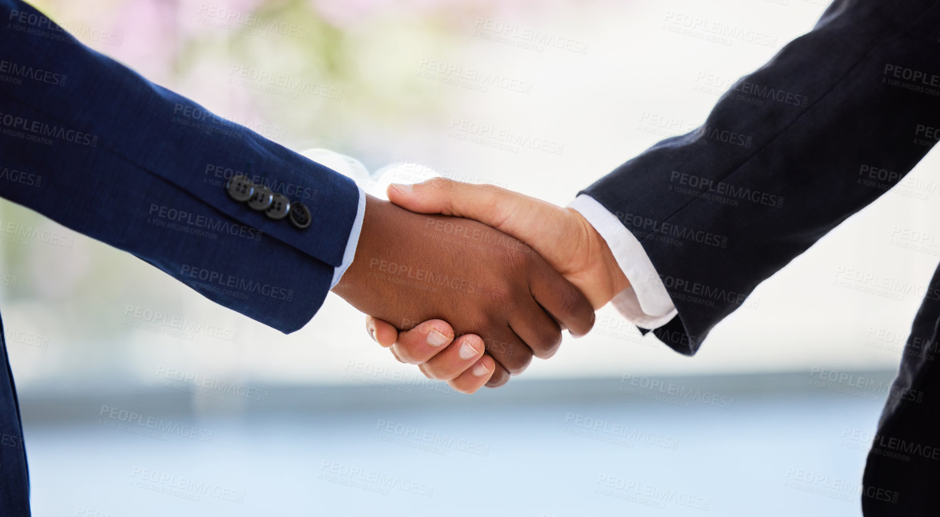 Buy stock photo Shot of two unrecognisable businessmen shaking hands in a modern office