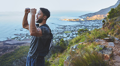 Buy stock photo Shot of a young man celebrating the completion of his hike at the top of the mountain
