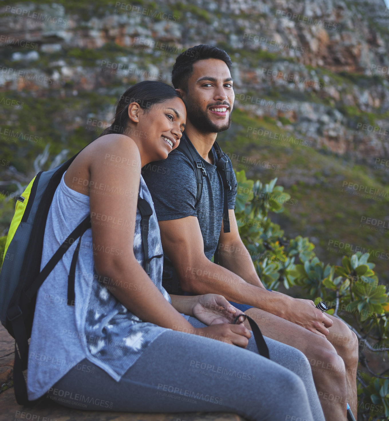 Buy stock photo Shot of a young couple enjoying the sunset view while out on a hike on a mountain range