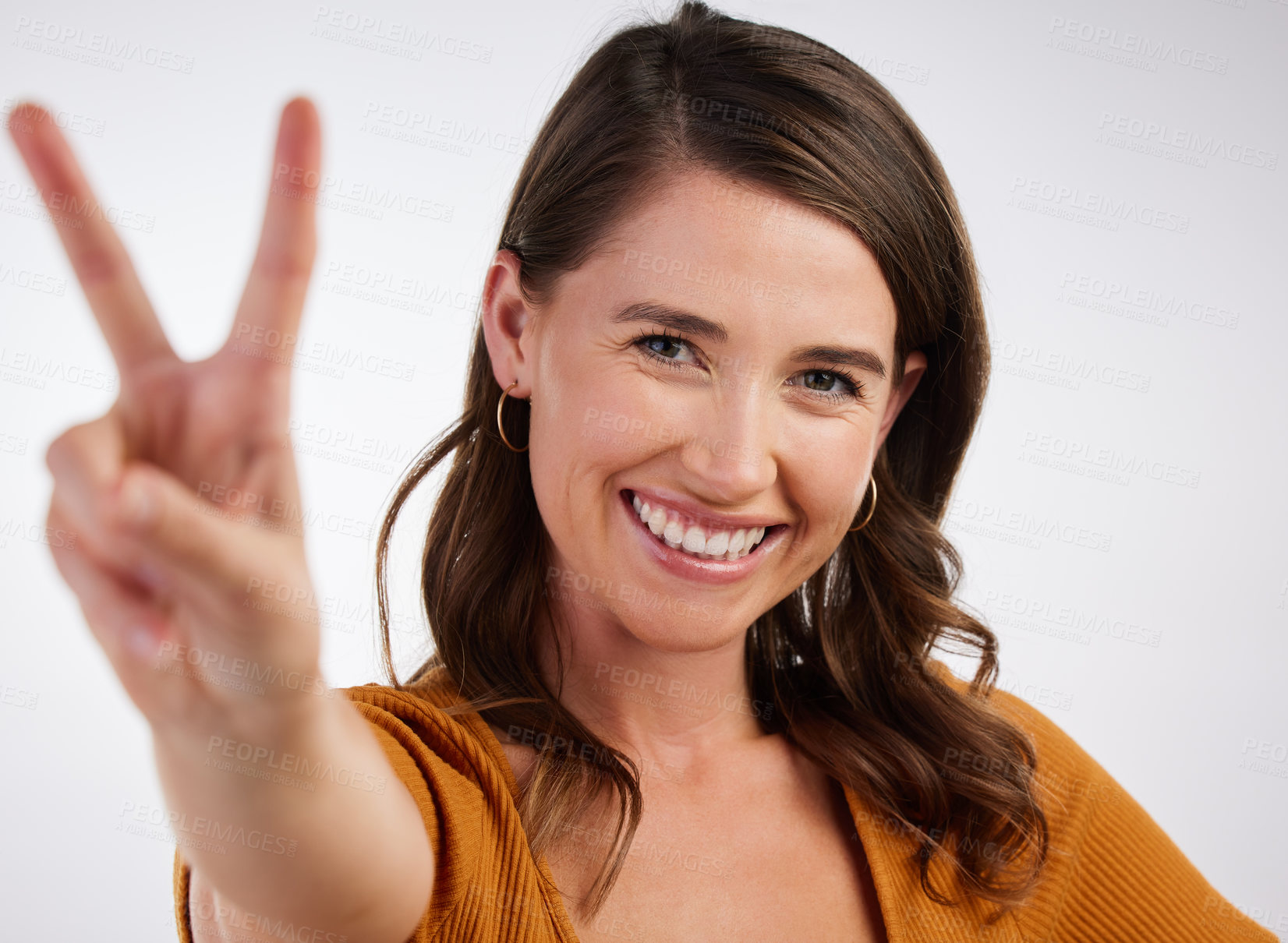 Buy stock photo Studio shot of a young woman showing a peace sign with her hand against a white background