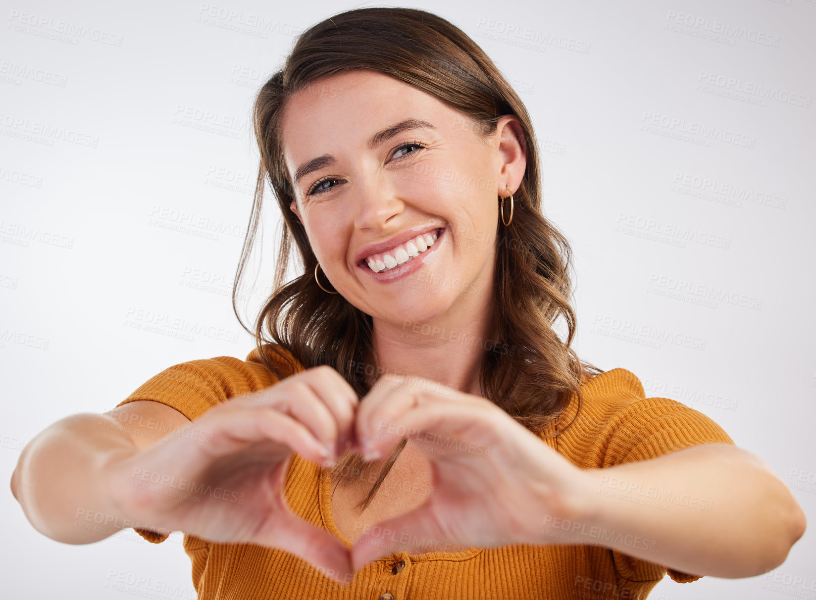 Buy stock photo Happy woman, portrait and heart hands with love in care, romance or kindness on a gray studio background. Young female person with smile for shape, like emoji or support for review, gesture or symbol