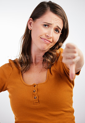 Buy stock photo Studio shot of a young woman showing thumbs down against a white background