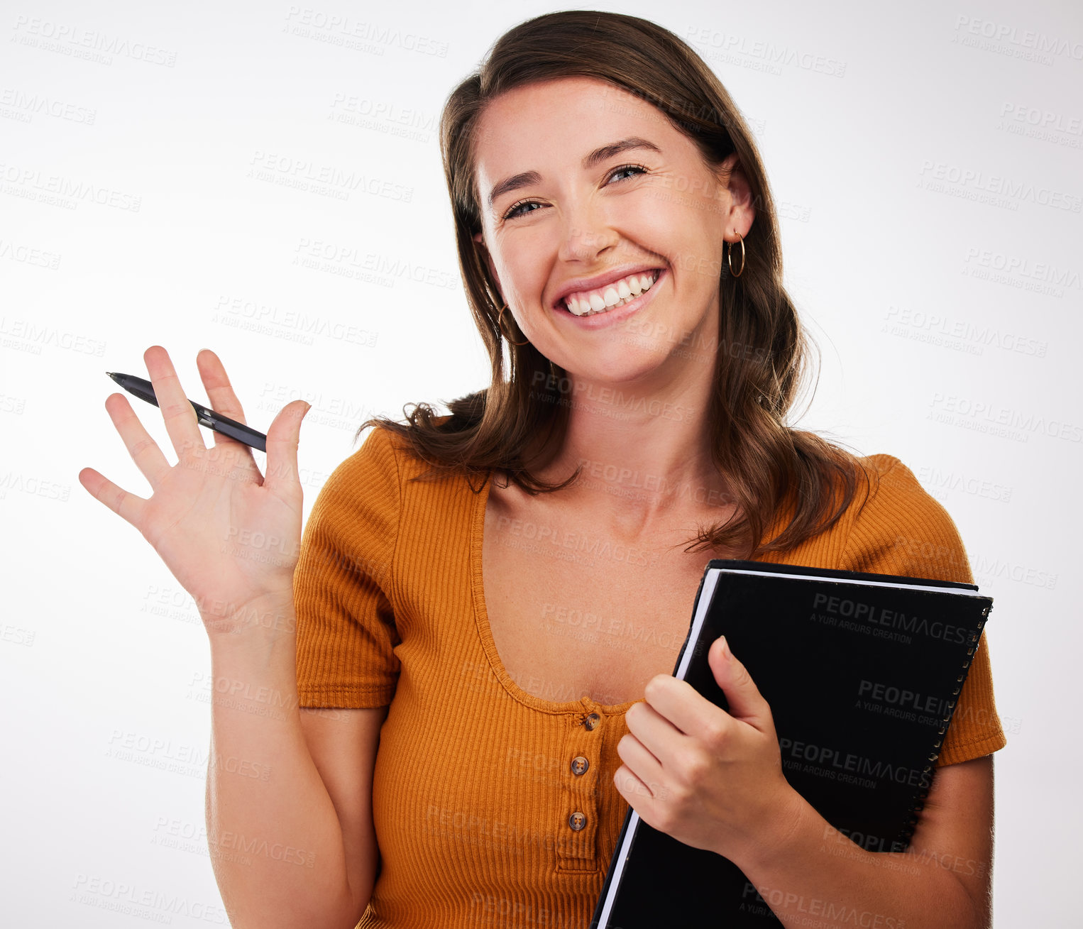 Buy stock photo Studio shot of a young woman holding a book and a pen against a white background