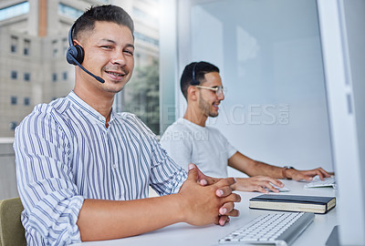 Buy stock photo Shot of two business colleagues working together at their desks in their office