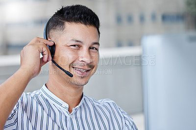 Buy stock photo Shot of a young businessman working in a call center office helping a client