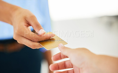 Buy stock photo Shot of two people exchanging bank cards to complete a purchase