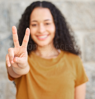 Buy stock photo Shot of a woman showing the peace sign while standing outside