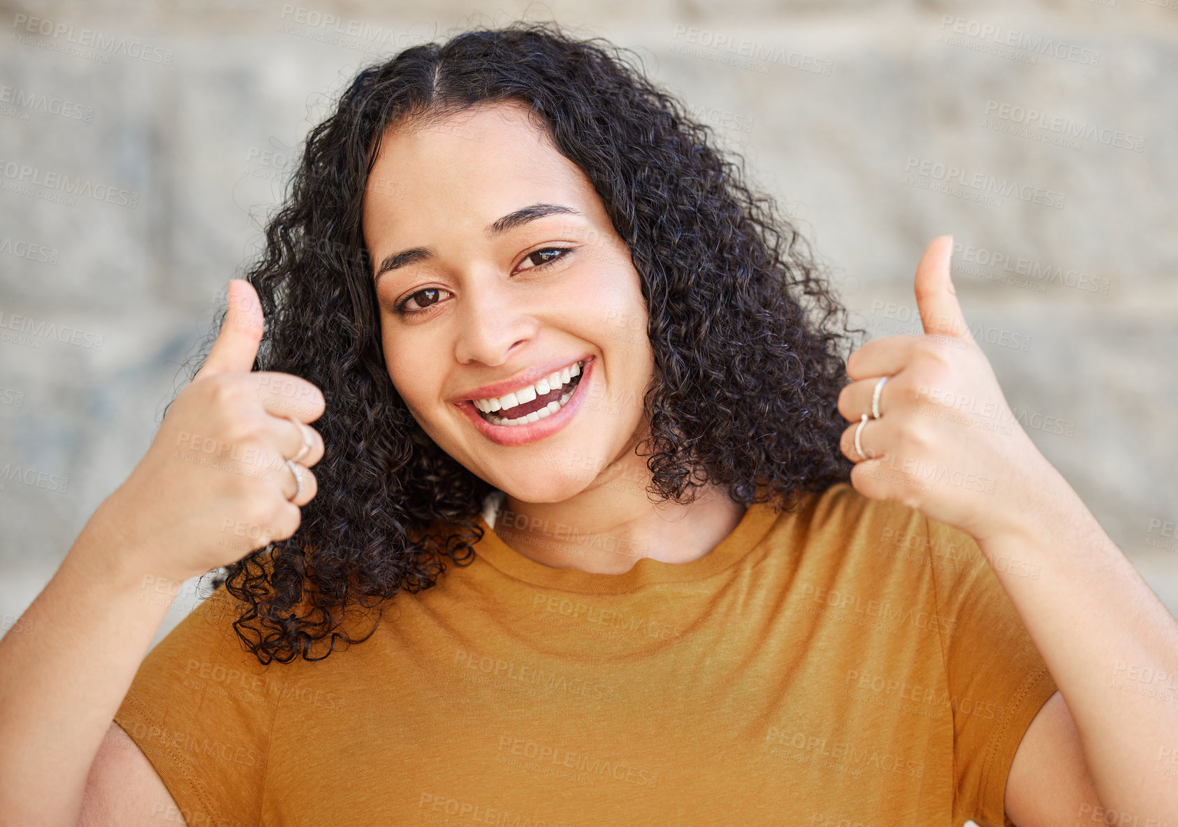 Buy stock photo Shot of a young woman showing thumbs up while standing outside