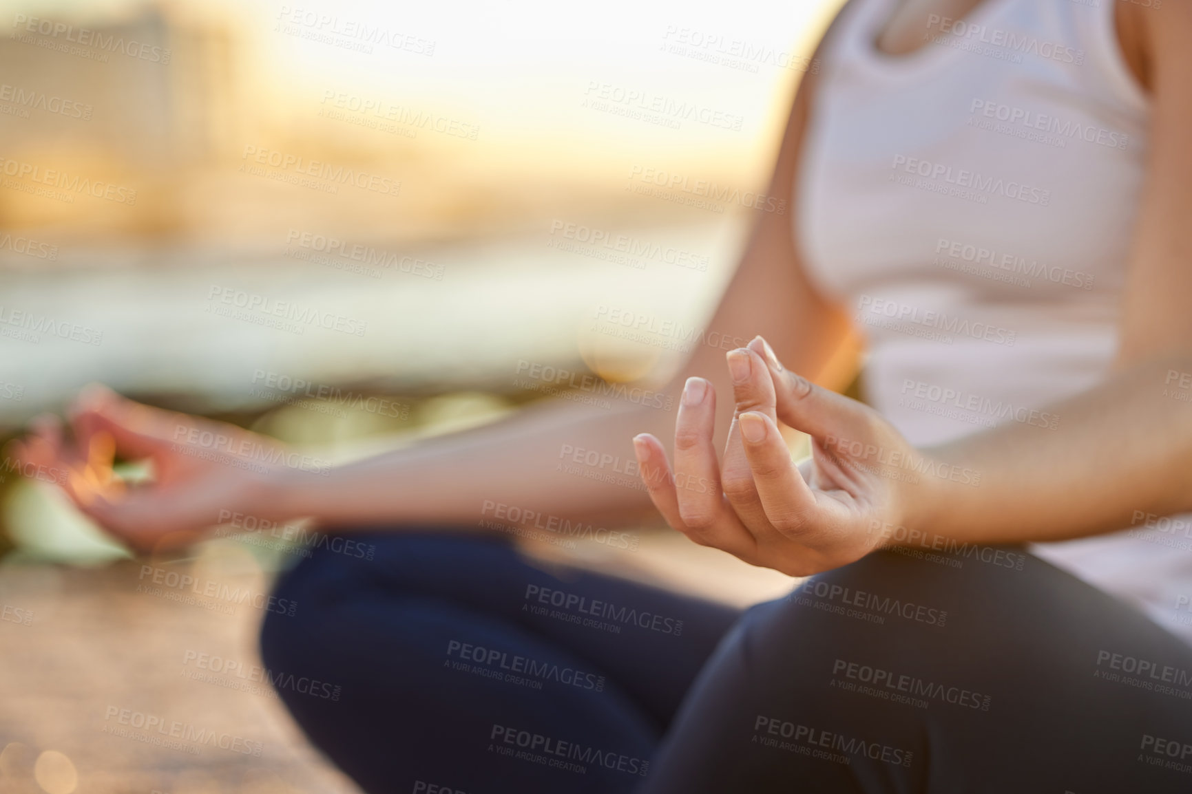 Buy stock photo Cropped shot of an unrecognizable young woman meditating on the beach