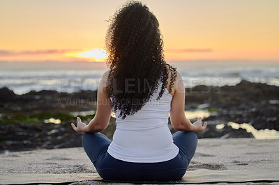 Buy stock photo Rearview shot of an unrecognizable young woman meditating on the beach