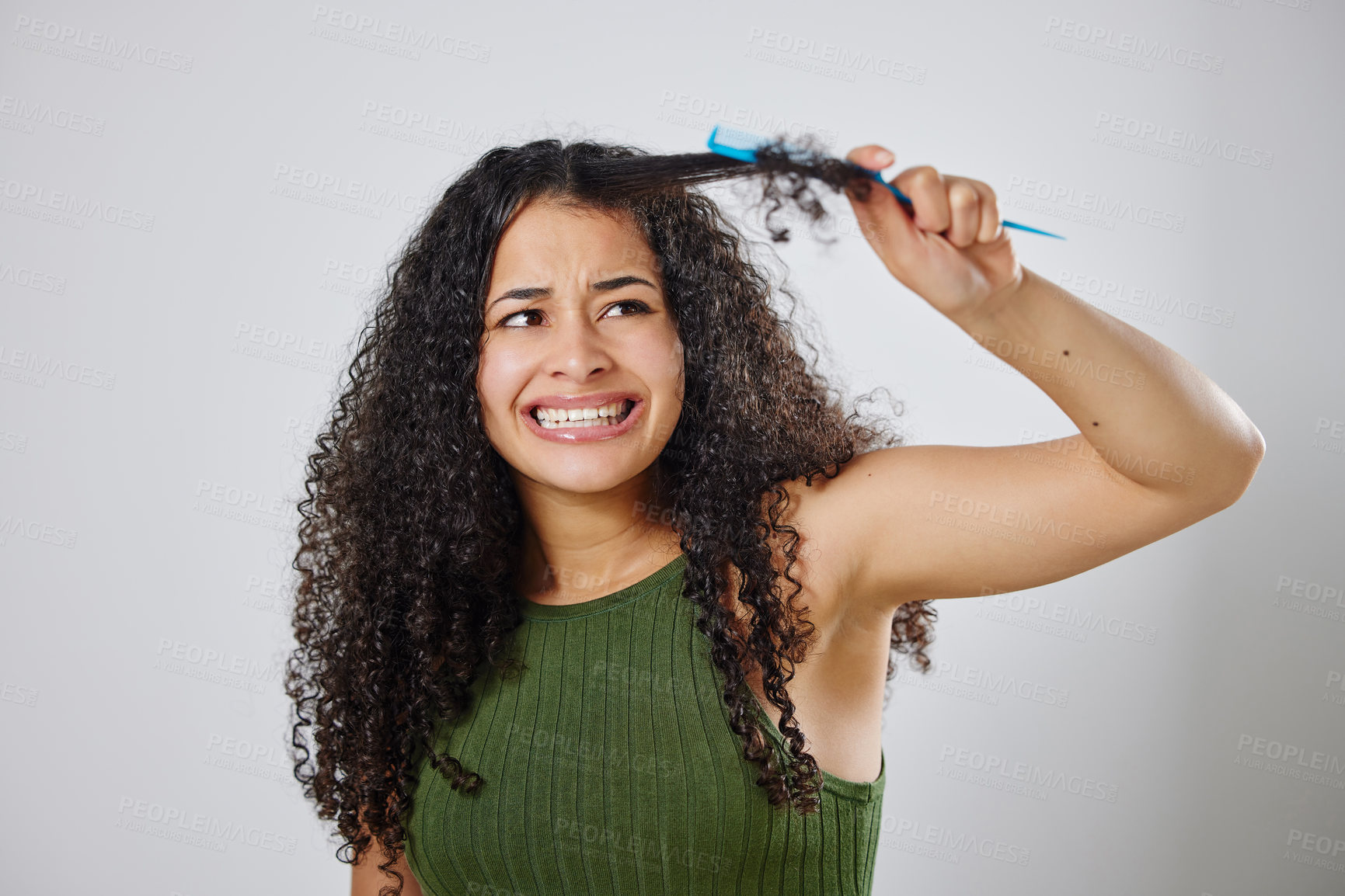 Buy stock photo Messy hair, knot and scared woman with comb in studio for tangle, stress and problem on grey background. Curly, haircare and model with anxiety for brushing fail, damage or styling hairloss results