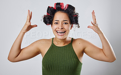Buy stock photo Cropped shot of a young woman posing with hair rollers against a grey background
