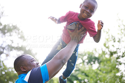 Buy stock photo Shot of a young boy playing with his father outside