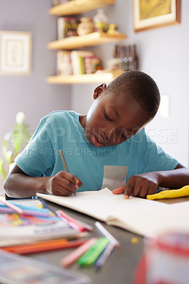 Buy stock photo Shot of a young boy spending his time colouring in pictures
