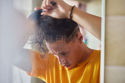 Buy stock photo Man, brush hair and morning by mirror for grooming, care or hygiene with thinking in home bathroom. Person, hairstyle and routine for cosmetics, growth and wellness for cleaning, reflection or check